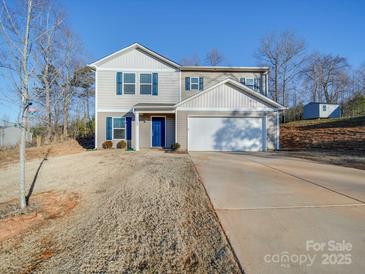 Two-story house with a gray exterior, blue door, and a two-car garage at 162 Four Andrews Dr, Harmony, NC 28634