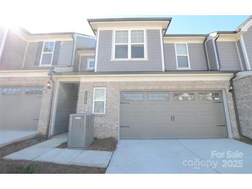 Modern two-story townhome with attached garage and neutral colors at 1819 Teachers House Nw Rd, Concord, NC 28027