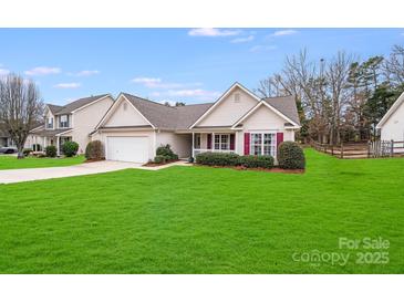 Charming one-story home with well-manicured lawn, attached garage, and inviting front porch at 2213 Genesis Dr, Monroe, NC 28110