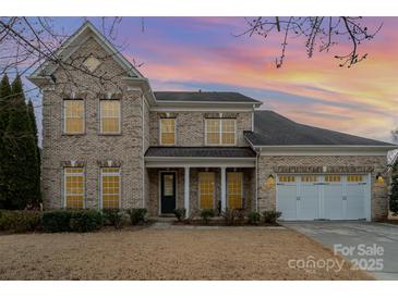 Charming two-story brick home with a well-manicured lawn and attached two-car garage at 3013 Misty Moss Ct, Waxhaw, NC 28173