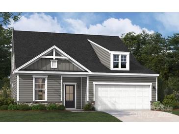 Gray two-story house with white garage door and landscaping at 3209 Whispering Creek Dr # 154, Indian Trail, NC 28079