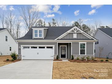 Gray house with white garage door and landscaping at 3209 Whispering Creek Dr, Indian Trail, NC 28079