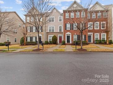 Three-story townhouses with brick and stone exteriors, showcasing a charming streetscape at 5636 Whitehawk Hill Rd, Mint Hill, NC 28227