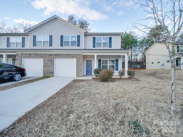 Two-story townhome with gray siding, brick accents, and a two-car garage at 1033 Cedar Village Trl, Salisbury, NC 28147