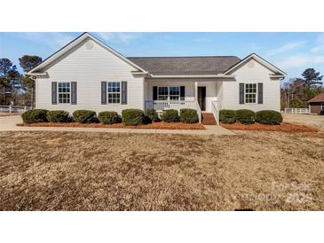 White house with gray shutters, a front porch, and landscaping at 1409 Bicycle Ct, York, SC 29745