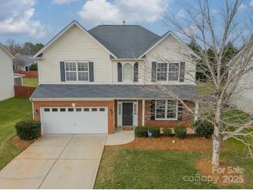 Two-story house with brick and siding exterior, a two-car garage, and a well-manicured lawn at 2131 Ashley Glen Way, Indian Land, SC 29707