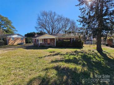 Brick ranch house with a large front yard and mature trees at 214 Costner Dr, Bessemer City, NC 28016