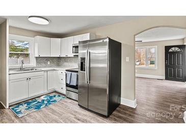 Modern kitchen featuring white cabinets, stainless steel appliances, and stylish herringbone backsplash at 2829 1St Nw Ave, Hickory, NC 28601