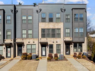 Three-story townhouses with gray siding, brick accents, and walkways at 414 W Tremont Ave, Charlotte, NC 28203