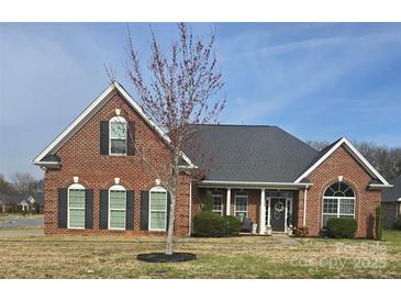 Charming brick home with a manicured lawn and a welcoming front porch at 5421 Roberta Meadows Ct, Concord, NC 28027