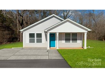 Newly constructed home featuring a light gray exterior, a teal front door, and a neatly landscaped lawn at 510 Jones St # 6, Chester, SC 29706