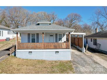 White house with wooden porch and gray brick base at 504 Washington St, Cramerton, NC 28032