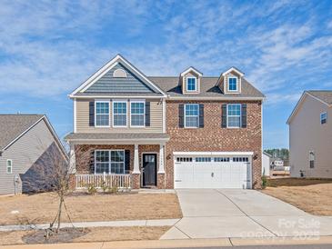 Two-story home featuring mixed brick and siding, black shutters, dormers and an attached two car garage at 7324 Teague Dr, Gastonia, NC 28056