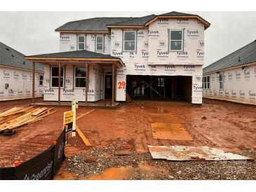 New construction home featuring a covered entry and attached two-car garage in an active construction zone at 1016 Farm Branch Ct, Indian Trail, NC 28079