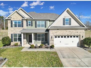 Charming two-story home with brick accents, landscaped yard, and two-car garage at 1169 Hollis Sw Cir, Concord, NC 28025