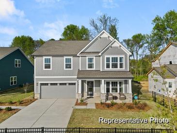 Two-story home with gray siding, two-car garage, and front porch at 118 Ryan Ln # 7139, Mooresville, NC 28115