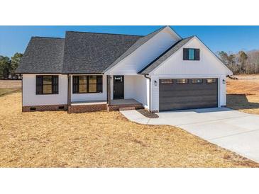 White farmhouse exterior with dark gray garage door and landscaping at 343 North Brook Iii School Rd, Vale, NC 28168