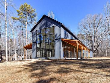 Modern barn-style home with large windows and covered porch at 5700 Mcwhorter Rd, Waxhaw, NC 28173