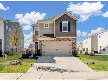 Charming two-story home with a two-car garage and a combination of stone and siding exterior at 571 Palmarosa St # 130, Fort Mill, SC 29715