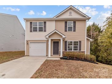 Two-story house with beige vinyl siding, a white garage door, and landscaping at 16115 Preston Knoll Ln, Charlotte, NC 28215