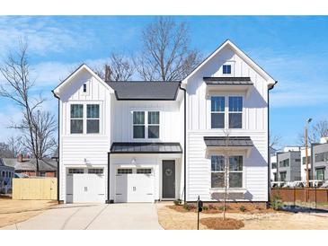 A charming two-story white home with a manicured lawn and a two-car garage, perfect for modern living at 1739 Dunloe St # 8242, Charlotte, NC 28206