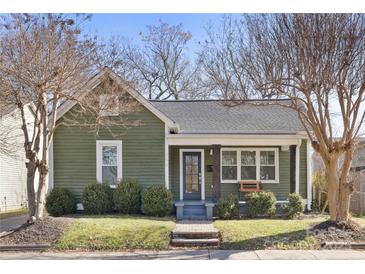 Charming home featuring green siding, covered porch, and mature trees in a well-maintained front yard at 506 Campus St, Charlotte, NC 28216