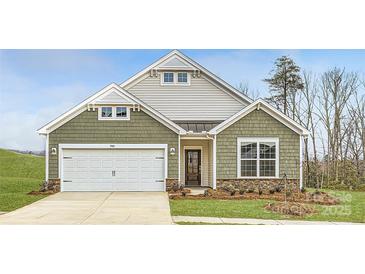 Curb appeal abounds in this charming one-story home, showcasing a two-car garage and well-manicured landscaping at 5901 Oak Branch Cir, Maiden, NC 28650