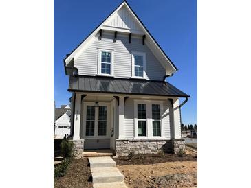 Two-story craftsman home with gray siding, black metal roof, and stone accents at 718 Barrel Aly, Fort Mill, SC 29715