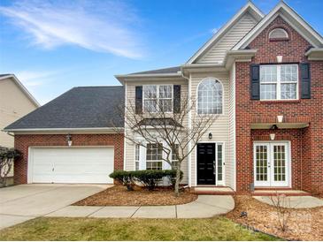 Two-story brick and beige house with a white garage door and landscaping at 8200 Suttonview Dr, Charlotte, NC 28269