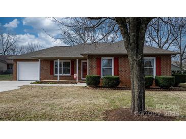 Brick ranch house with a white garage door, red shutters, and landscaping at 125 1St N Ave, Conover, NC 28613