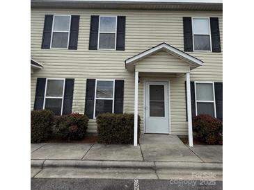 Two-story beige vinyl sided building with black trimmed windows and a covered entry at 217 22Nd Sw St # H, Hickory, NC 28602