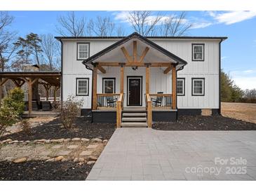 Charming two-story home with black and white design, wood accents, and a welcoming front porch at 4747 Kenneths Dr, Maiden, NC 28650