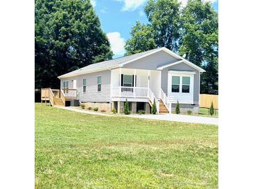 Charming single-story home boasts a well-manicured lawn and classic architectural details at 507 E Lackey Farm Rd, Stony Point, NC 28678
