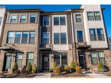 Three-story townhome with brick and gray siding, showcasing a modern design at 824 Broad River Ln, Charlotte, NC 28211