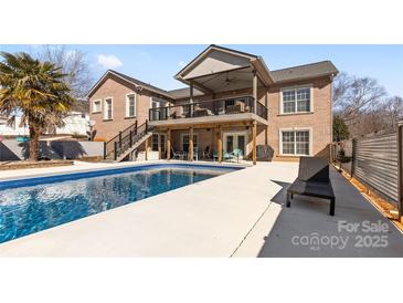 Inviting backyard oasis featuring a sparkling pool, expansive deck, and covered patio at 150 Heathrow Ln, Statesville, NC 28677