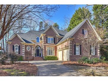 Brick home with two-car garage, landscaping, and large driveway at 16512 Pelican Point Ln, Cornelius, NC 28031