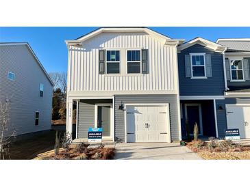 Two-story townhome with gray and white siding, a white garage door, and landscaping at 3530 Backwater St, Concord, NC 28027