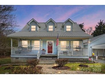 Charming home with a welcoming front porch, metal roof, and well-maintained landscaping at 16338 Silver Rd, Oakboro, NC 28129