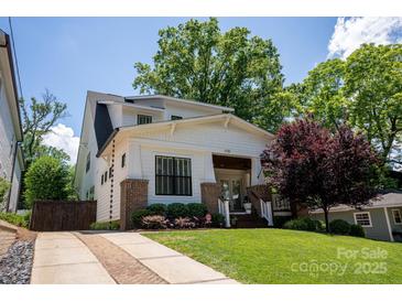 Two-story craftsman home with brick and white siding, charming front porch, and manicured lawn at 1725 Dunkirk Dr, Charlotte, NC 28203