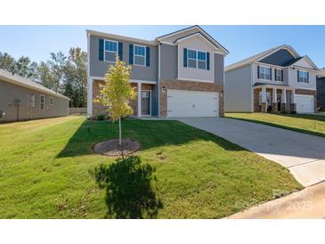 Beautiful two-story home featuring gray siding, stone accents, a two-car garage, and a well-manicured lawn at 1758 Falls Cove Rd, Newton, NC 28658