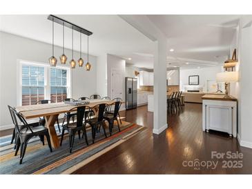 Open dining room featuring a large wooden table with decorative lighting and hardwood floors at 212 Bacon Ave, Charlotte, NC 28208