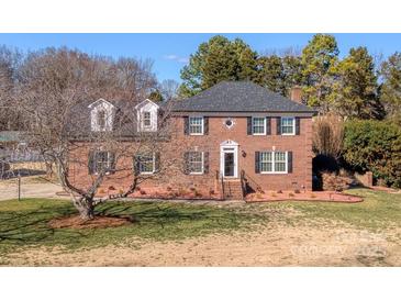 Brick house with a two-car garage and landscaping at 5438 Somerset Ln, Harrisburg, NC 28075