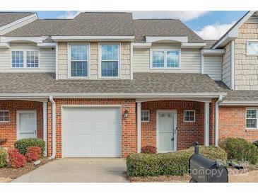 Brick front exterior of townhome with attached garage and landscaping at 315 Valley Brook Se Ln, Concord, NC 28025