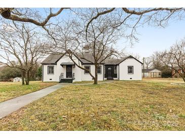 Charming exterior of white brick home with black trim and manicured lawn at 912 Hickory Grove Rd, Gastonia, NC 28056