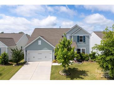 Charming two-story home with a well-manicured lawn, and a two car garage at 5034 Moselle Ave, Fort Mill, SC 29707