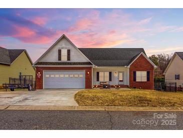 Charming single-Gathering home featuring a brick and white facade, two-car garage, and well-maintained front yard at 103 Granville Ln, Salisbury, NC 28146