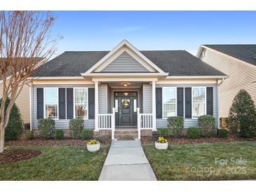 Charming single-story home featuring a welcoming front porch, manicured lawn, and dark shutters at 11508 Dublin Crescent Rd, Cornelius, NC 28031