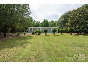 Charming single-story home featuring a well-maintained lawn, mature trees, and neutral siding at 3035 Agean Ln, York, SC 29745