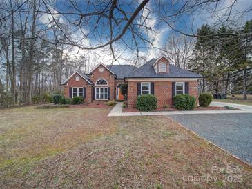 Brick house with gray roof, landscaping, and a paved driveway at 3119 Drake Ln, Monroe, NC 28110