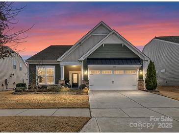 Charming single-Gathering home with a well-manicured lawn and an attached two-car garage at twilight at 3207 Oliver Stanley Trl, Lancaster, SC 29720